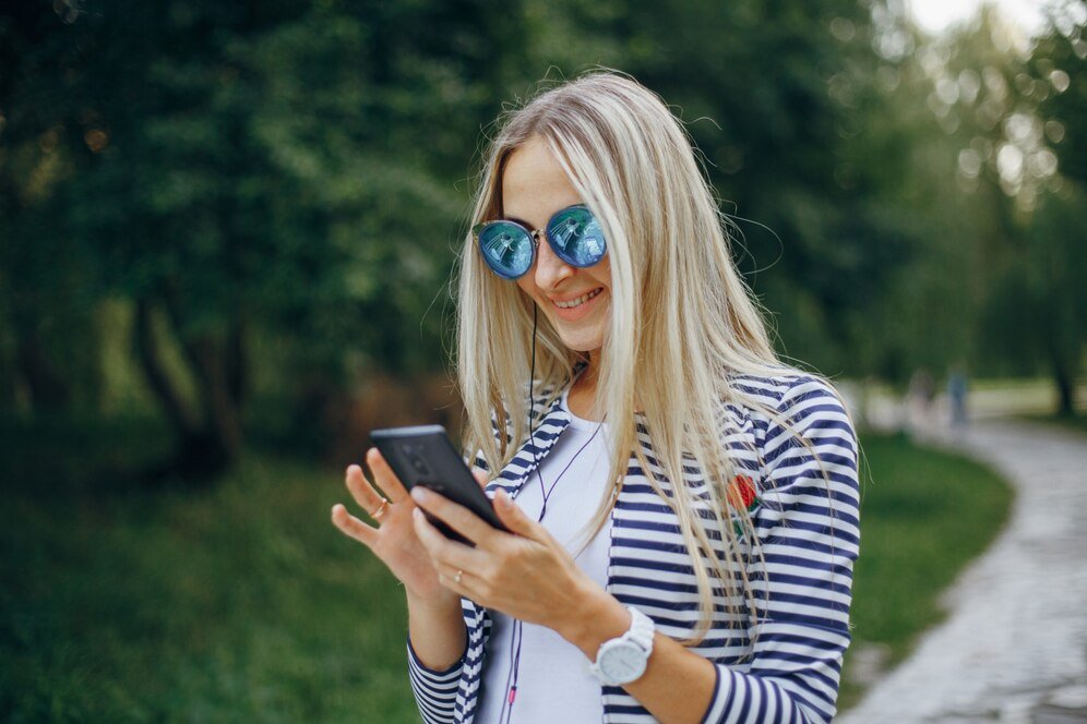 Women using phone while wearing blue glasses