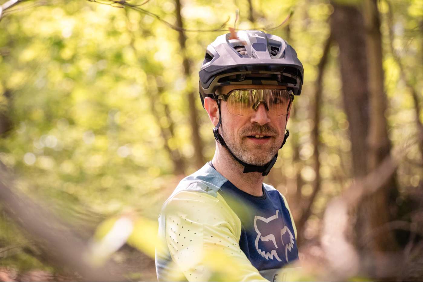 Portrait of a male mountain biker in the forest on a sunny spring day.