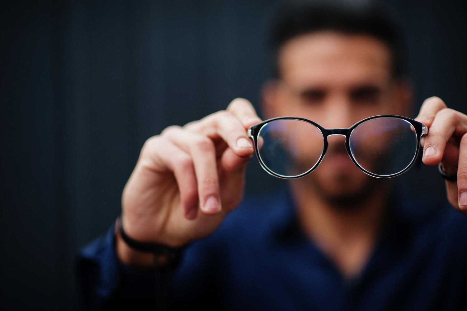 a man holding his glasses